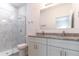 Modern bathroom with double sinks, granite countertops, and a tiled shower with glass door at 13 Oak Trail Pl, Ocala, FL 34472