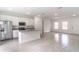 Open-concept kitchen with stainless steel appliances and island flowing into the living area with natural light at 13 Oak Trail Pl, Ocala, FL 34472
