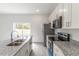 Bright kitchen featuring stainless steel appliances, granite countertops, and a sliding door to the outdoors at 13 Oak Trail Pl, Ocala, FL 34472