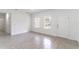 Well-lit living room features tile floors, a large window, and a door leading to a bathroom at 13 Oak Trail Pl, Ocala, FL 34472