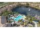 Stunning aerial view of a pool, lush landscaping, and a tranquil lake with fountain at 1357 Venezia Ct # 302, Davenport, FL 33896