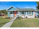 Charming single-story home with a manicured lawn, inviting walkway, and eye-catching orange door at 1422 Indiana Ave, St Cloud, FL 34769