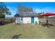 Charming cottage backyard, a green yard with a painted shed with a quaint blue door at 1422 Indiana Ave, St Cloud, FL 34769