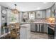 Well-lit kitchen features stainless steel appliances, gray cabinets, and eat-in table with designer backsplash at 1422 Indiana Ave, St Cloud, FL 34769