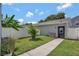 Charming backyard featuring a grassy area, walkway, privacy fence and string lights at 1607 Wilson Ave, Orlando, FL 32804
