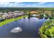 An aerial view of resort-style community featuring a beautiful lake with fountain, houses, and community pool at 195 Hideaway Beach Ln, Kissimmee, FL 34746