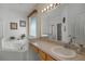 Bright bathroom featuring a bathtub with jacuzzi jets, large mirror, and a shower with glass door at 195 Hideaway Beach Ln, Kissimmee, FL 34746