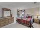 Bedroom featuring an ornate metal bed frame, a dresser with a large mirror and two side tables at 195 Hideaway Beach Ln, Kissimmee, FL 34746