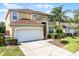 Charming two-story home featuring an attached garage, well-maintained landscaping, and a welcoming entrance at 195 Hideaway Beach Ln, Kissimmee, FL 34746