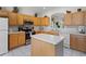 Bright kitchen with wood cabinets, an island, white countertops, and modern appliances, offering a functional design at 195 Hideaway Beach Ln, Kissimmee, FL 34746