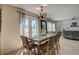Sunlit dining area featuring an outdoor view, modern table setting, and easy access to the living room at 2024 Bearing Ln, Kissimmee, FL 34744