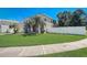 Exterior elevation of the two story home with lush green lawn and white privacy fence at 2024 Bearing Ln, Kissimmee, FL 34744