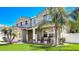 Charming two-story home featuring a well-manicured lawn and tropical landscaping, creating a welcoming curb appeal at 2024 Bearing Ln, Kissimmee, FL 34744