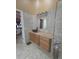 Bathroom with warm tile and cabinets, and decorative mirror above the vessel sink at 204 Canary Island Cir, Davenport, FL 33837