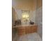 Bathroom featuring tiled walls, double sinks with granite counters, wooden cabinets and a decorative mirror at 204 Canary Island Cir, Davenport, FL 33837