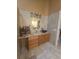 Bathroom with wood cabinets and dual vanities, with tile flooring and half-wall shower at 204 Canary Island Cir, Davenport, FL 33837