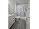 Bathroom with white vanity, gray floors and a bathtub with a marble shower curtain at 204 Canary Island Cir, Davenport, FL 33837