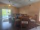 Living room view with wood floors, ceiling fan, and sliding glass door to pool area at 204 Canary Island Cir, Davenport, FL 33837