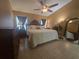 Spacious primary bedroom featuring tile floors, a ceiling fan, and a large mirror for added style at 204 Canary Island Cir, Davenport, FL 33837