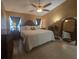 Bright primary bedroom featuring a ceiling fan, warm neutral walls, and a large mirror for added style at 204 Canary Island Cir, Davenport, FL 33837