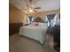 Bright primary bedroom featuring a ceiling fan, warm neutral walls, and a large mirror for added style at 204 Canary Island Cir, Davenport, FL 33837