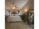 Spacious primary bedroom featuring tile floors, a ceiling fan, and a large mirror for added style at 204 Canary Island Cir, Davenport, FL 33837