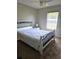 This bedroom has a black and white queen-sized bed and a window with horizontal blinds at 2141 Fawn Meadow Cir, St Cloud, FL 34772