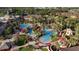 Beautiful aerial view of a resort-style pool area with palm trees, red umbrellas, and several pools connected by a lazy river at 226 Verona Ave, Davenport, FL 33897