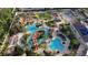 Aerial view of a luxurious resort-style pool featuring a lazy river, lounge chairs, and lush landscaping with palm trees at 226 Verona Ave, Davenport, FL 33897