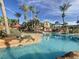 Resort-style pool area with palm trees, lounge chairs, and a tropical waterfall at 226 Verona Ave, Davenport, FL 33897