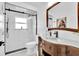 Modern bathroom with a walk-in shower, black fixtures, and a wooden vanity with a white countertop at 2402 Raven Croft Ct, Orlando, FL 32837