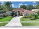 The front of a well maintained home with a green lawn and a circular driveway at 2402 Raven Croft Ct, Orlando, FL 32837