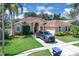 View of the front of the home and the circular driveway with a parked vehicle at 2402 Raven Croft Ct, Orlando, FL 32837