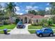 View of the front of the home and its circular driveway with multiple parked vehicles at 2402 Raven Croft Ct, Orlando, FL 32837