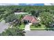 An angled view of the exterior of the home with lush landscaping and a tile roof at 2402 Raven Croft Ct, Orlando, FL 32837