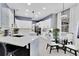 Bright kitchen featuring white cabinets, quartz countertops, tile floors, and a breakfast bar with pendant lighting at 2402 Raven Croft Ct, Orlando, FL 32837