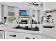 Open concept kitchen with black sink, stainless faucet, white cabinetry and living room view with fireplace and TV at 2402 Raven Croft Ct, Orlando, FL 32837