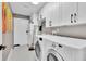 Laundry room showcasing a washing machine, dryer, cabinets and a utility sink at 2402 Raven Croft Ct, Orlando, FL 32837