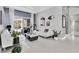Living room features neutral walls, tile floors, white sofas, and sliding glass doors to an outdoor pool area at 2402 Raven Croft Ct, Orlando, FL 32837