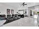 Living room with tile floors, black leather seating, a ceiling fan, and an open layout to the kitchen and dining area at 2402 Raven Croft Ct, Orlando, FL 32837