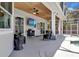 Covered patio with ceiling fans, lighting, outdoor furniture and TV, leading to the screened pool area at 2402 Raven Croft Ct, Orlando, FL 32837