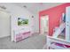 bedroom featuring a pink accent wall, bunk beds, and an adjacent bathroom at 2525 Shanti Dr, Kissimmee, FL 34746