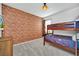 A bedroom with a brick accent wall, bunk beds, and a mounted TV at 2525 Shanti Dr, Kissimmee, FL 34746