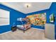 Bright bedroom featuring blue walls, carpet, and a bunk bed with comic book themed décor at 2525 Shanti Dr, Kissimmee, FL 34746