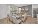 Elegant dining room with glass table, seating for ten, wood floors and modern art at 2525 Shanti Dr, Kissimmee, FL 34746