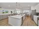 Modern kitchen with a large island, stainless steel appliances, and an open view of the living and dining areas at 2525 Shanti Dr, Kissimmee, FL 34746