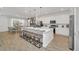 Open kitchen with a large island, seating, and stainless appliances flowing into the dining area at 2525 Shanti Dr, Kissimmee, FL 34746