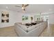 Open living room with a large sectional sofa, a wall-mounted TV, and access to the backyard through glass doors at 2525 Shanti Dr, Kissimmee, FL 34746