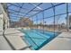 Sparkling screened-in pool area with ample seating and a clear blue sky above at 2525 Shanti Dr, Kissimmee, FL 34746