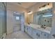 Bright bathroom with double sinks, white marble countertops, and a glass-enclosed shower at 2673 Calistoga Ave, Kissimmee, FL 34741